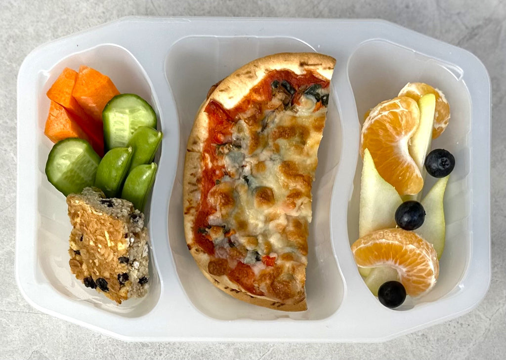 bento style school lunch pack including mini pizza, veggie sticks, oat slice and fruit
